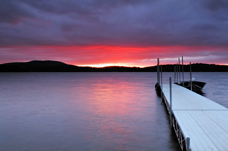 Stormy sunset and Red Top Inn boat dock at Tupper Lake New York